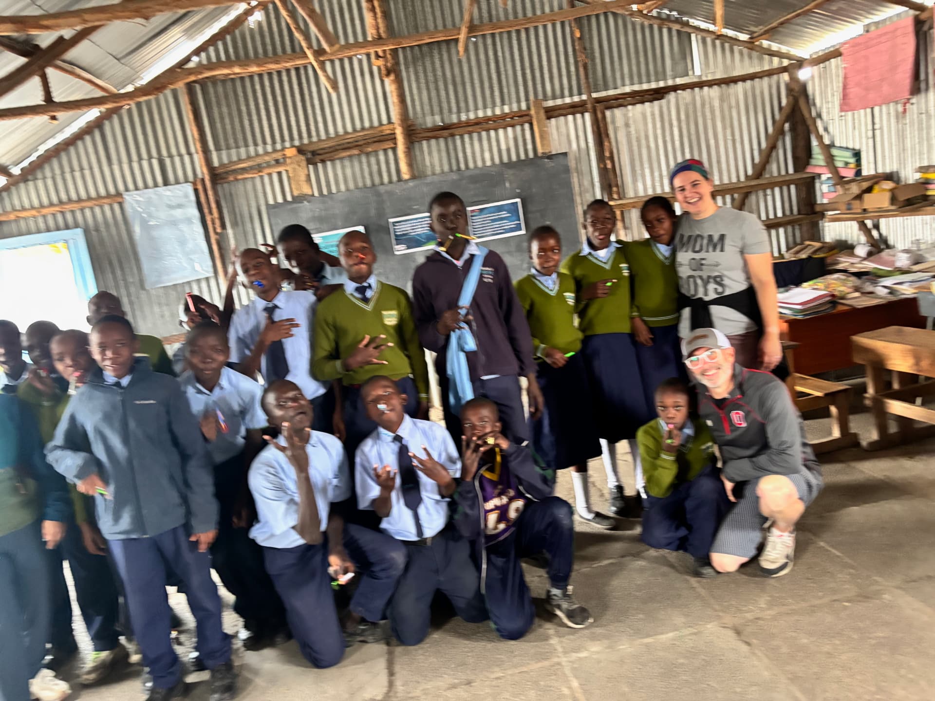 Team member and students smiling together in a classroom