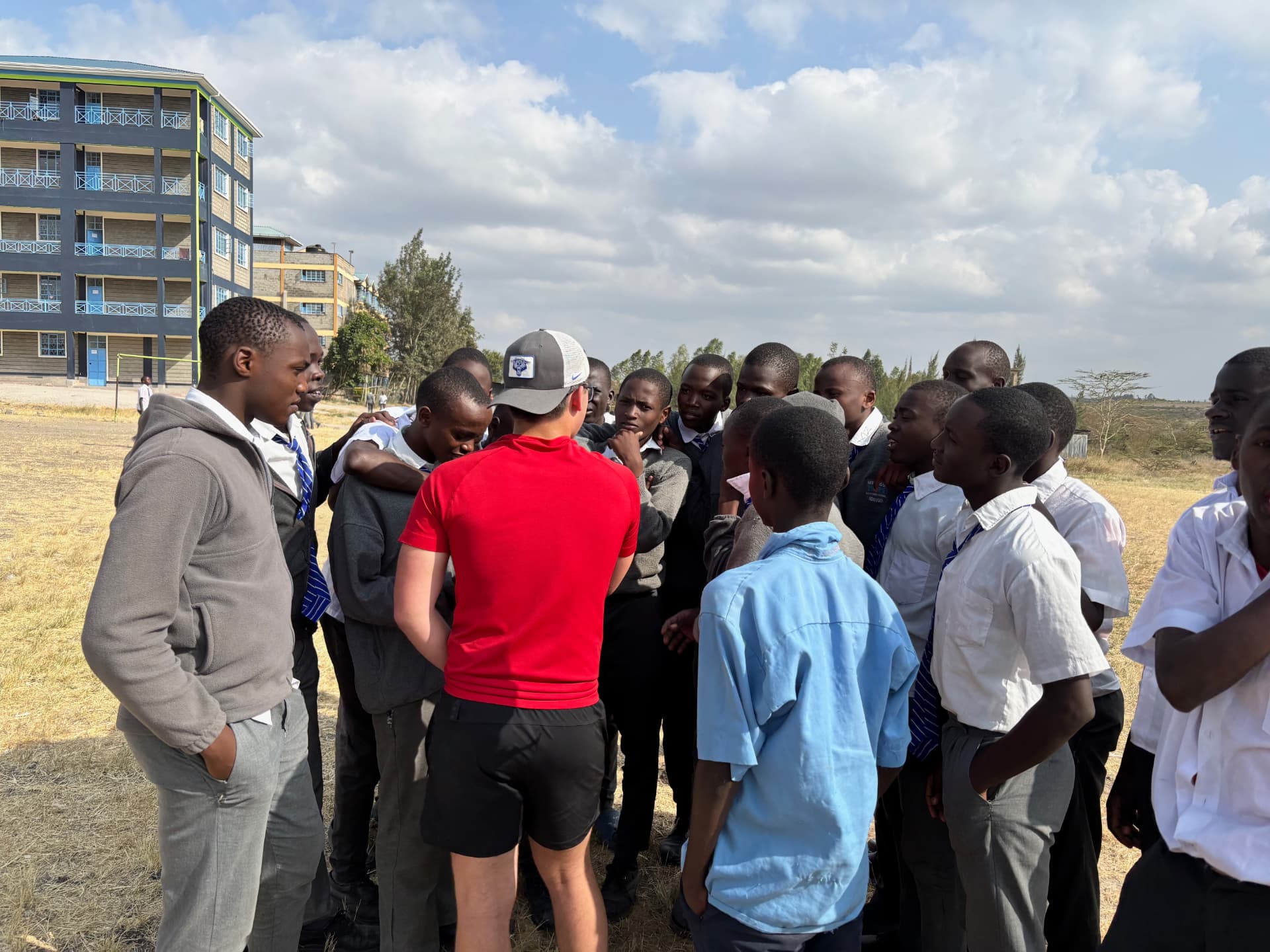 Parker surrounded by secondary students outdoors